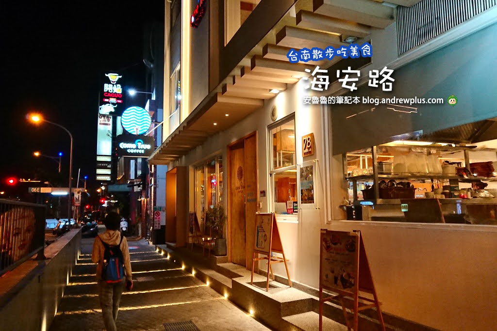 遊客在台南海安路街道美術館的壁畫與燈光裝置藝術前拍照打卡，旁邊是熱鬧的露天小吃酒吧 | 安魯魯的筆記本